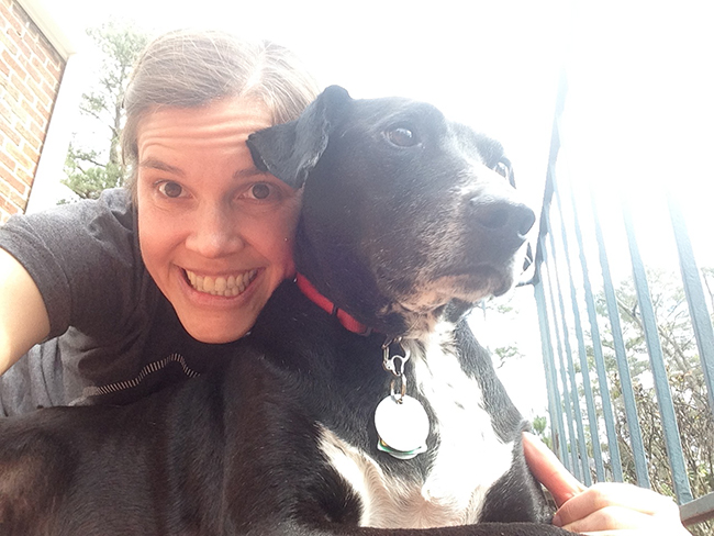 successful dog nail trimmer smiling with her rescue dog named banjo