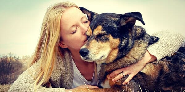 woman kissing dog