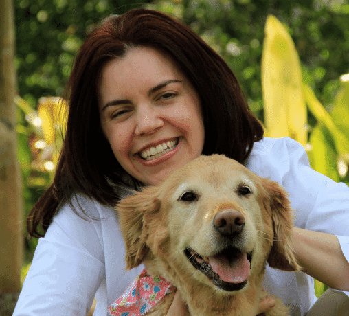 Dr. Julie Buzby, veterinarian, founder of Dr. Buzby's senior dog company and veterinary website, smiling with a happy Golden Retriever  