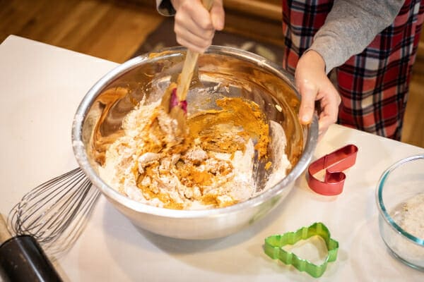 Mixing bowl with the ingredients for the holiday dog treats being stirred together, photo