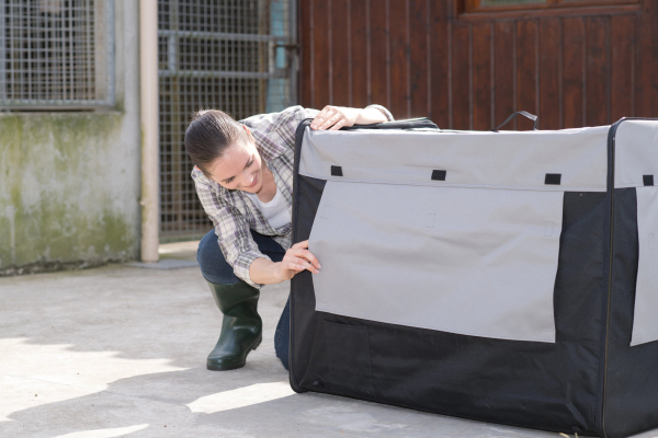 Owner looking into a soft fabric dog crate to choose the best dog crate for training