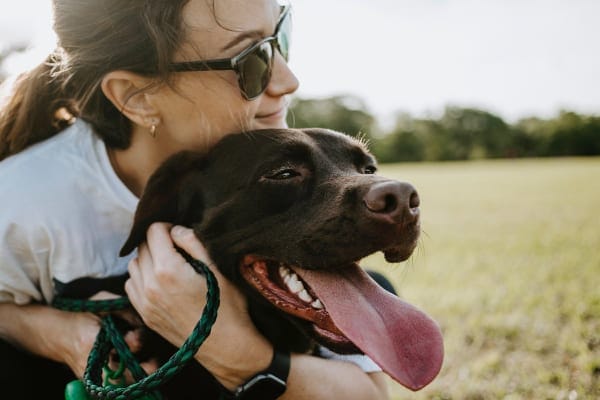 Dog mom hugging her chocolate lab, photo