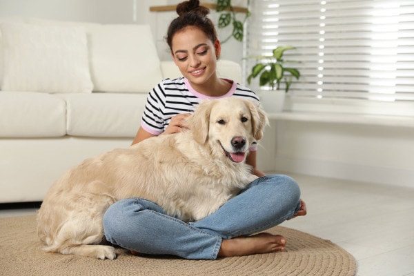 Owner sitting with her dog waiting to give an eye drop