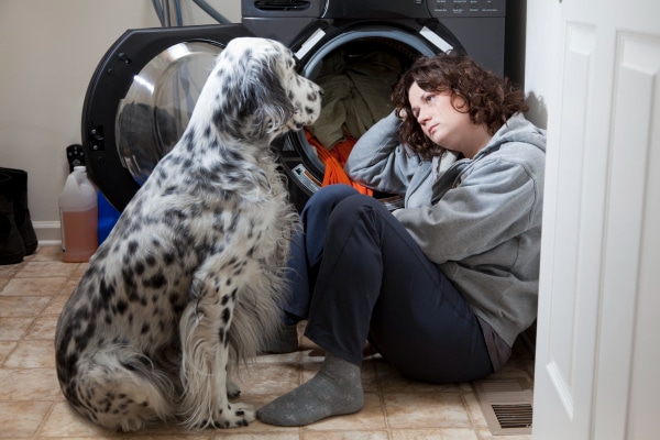 Dog sitting by his grieving owner in the laundry room