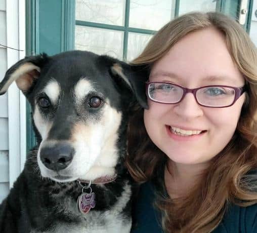 Veterinarian and veterinary blog writer Jessica Harris smiling and holding her senior dog