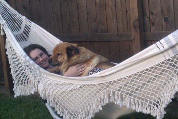 Bert, a dog diagnosed with melanoma, lying in a hammock with his owner