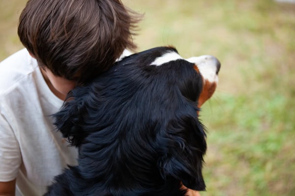 Boy hugging his dog anticipating loss of pet