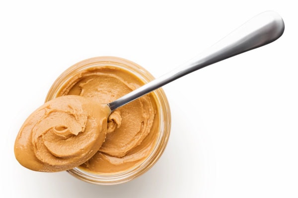 Peanut butter and spoon ready to hide a dog pill in